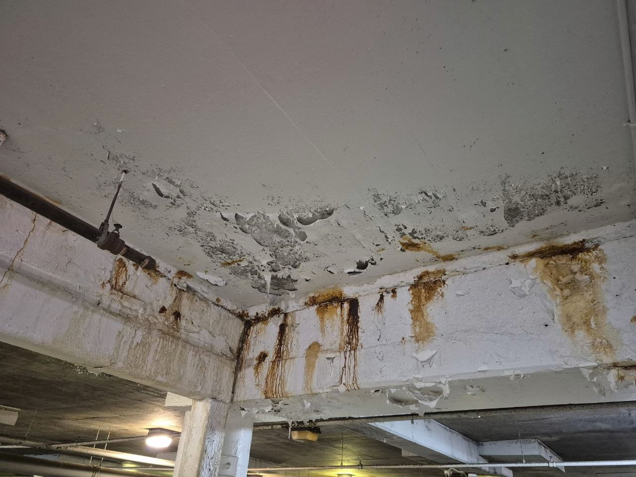 Exposed reinforcement and concrete damage in a parking structure